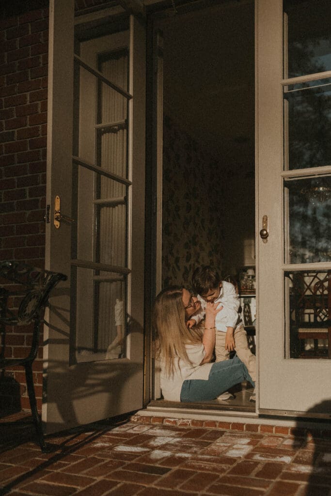 Mother sitting in doorway holding her toddler son during Southern Ohio motherhood session